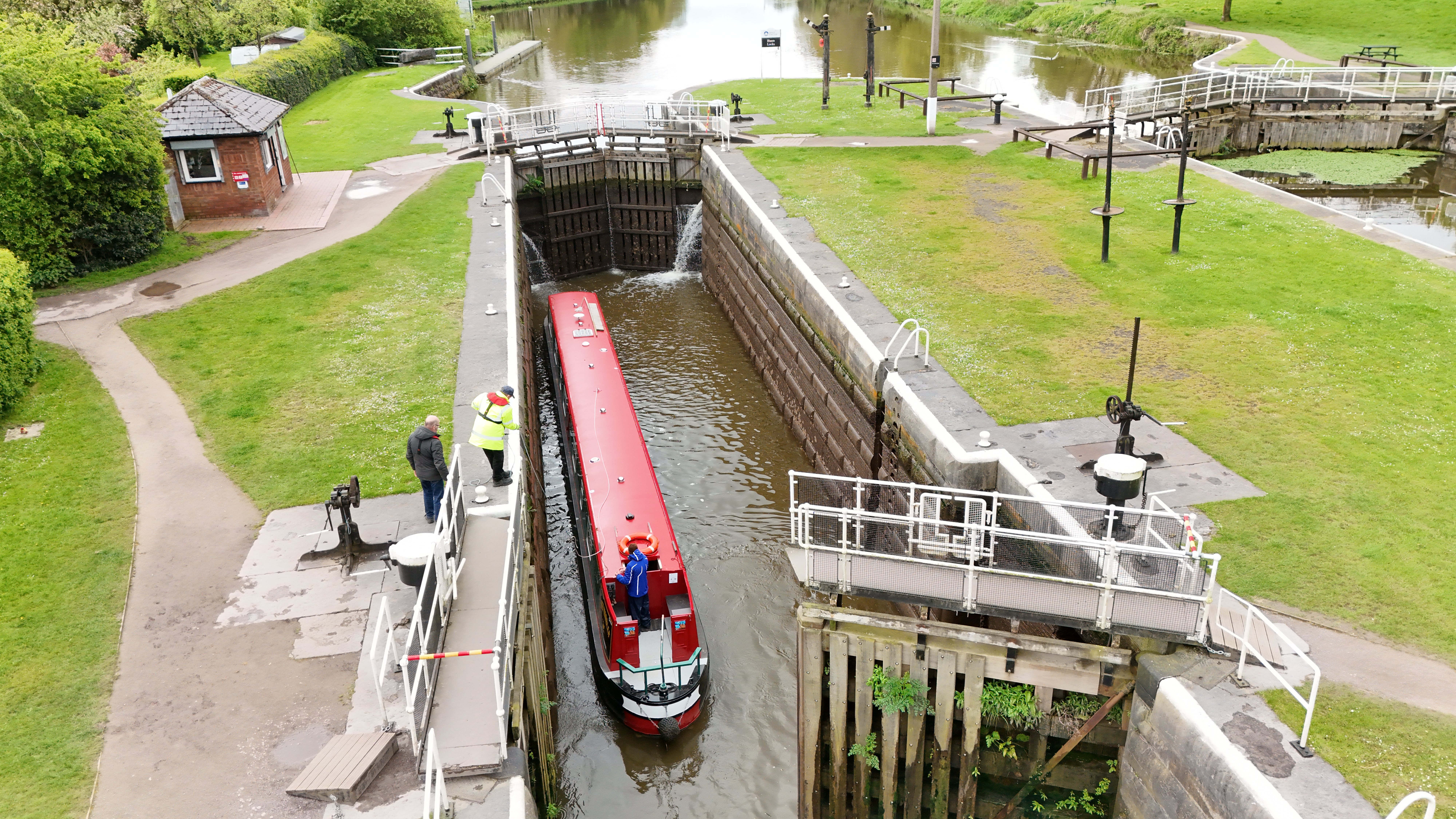 Aerial drone view of narrowboat entering a canal lock